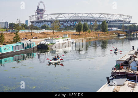 Menschen Kajakfahren auf dem Fluss Lea in Stratford mit London Stadium im Hintergrund, London England Vereinigtes Königreich UK Stockfoto