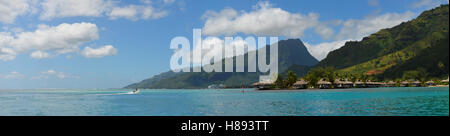 Panoramablick über die grünen Berge mit Resort und türkisblaue Lagune an der zerklüfteten Küste der tropischen Insel Moorea. Stockfoto