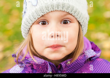 Lustig Lächeln kaukasischen kleines Mädchen Nahaufnahme outdoor Portrait, Wandern im herbstlichen Park Stockfoto