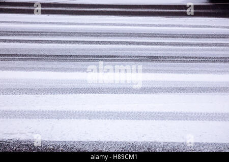 Reifen druckt in ersten Nassschnee auf Asphaltstraße Stockfoto