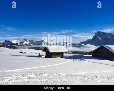 Alte hölzerne Scheunen, umgeben von tiefen Schnee mit Skipisten in den Dolomiten, Italien, Europa Stockfoto