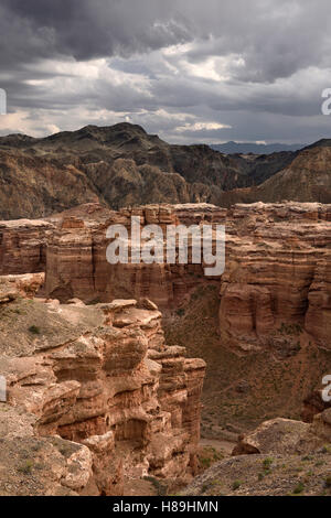 Dunkle Wolken über rote Sedimentschichten am Tscharyn-Canyon-Nationalpark-Kasachstan Stockfoto