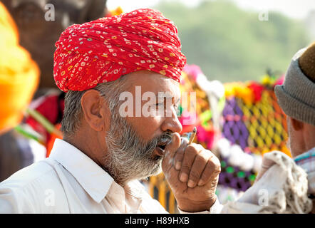 Porträt von einem nicht identifizierten Rauchen Rajasthani indische Mann besucht das Pushkar Fair, Indien Stockfoto