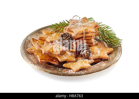 Zusammensetzung der Sterne geformt Ingwer Cookies und Tannenzapfen auf alten Metall-Teller auf weißem Hintergrund Stockfoto