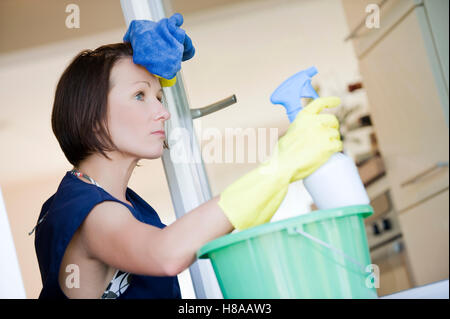 Erschöpft Putzfrau Reinigung der Fenster Stockfoto