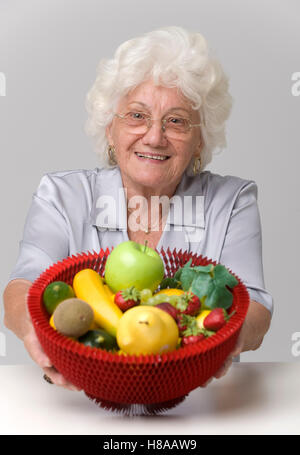 Ältere Frau mit Obstkorb Stockfoto