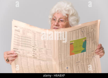 Ältere Frau liest eine Zeitung Stockfoto