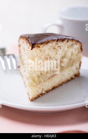 Hausgemachte Boston Cream Pie, Stück Kuchen mit einer Creme gefüllt und mit Schokolade, selektiven Fokus gefrostet Stockfoto