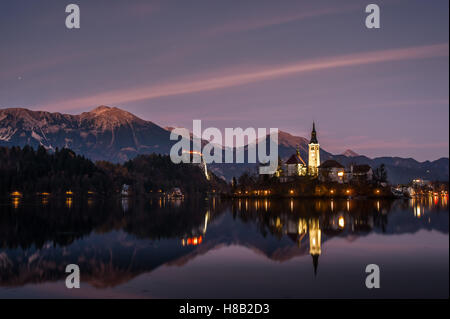 Kapelle auf einer kleinen Insel in der Dämmerung spiegelt sich in ruhigem Wasser, Bleder See in Slowenien Stockfoto