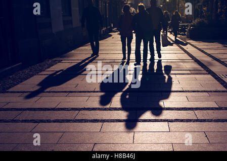 Silhouetten von Menschen zu Fuß auf Stadt Straße und Gießen Schatten auf Asphalt, allgemeine öffentliche Konzept für jede Gemeinschaft im Zusammenhang mit t Stockfoto