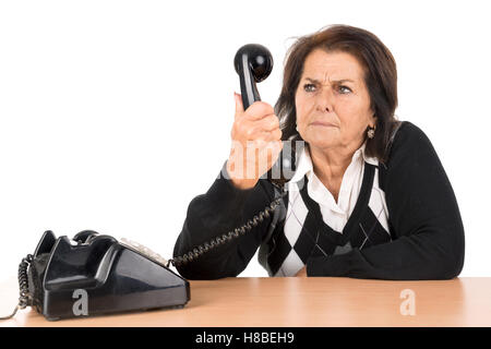 Wütend senior Frau mit alten Telefon isoliert in weiß Stockfoto