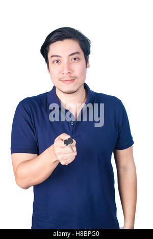 Asiatische gut aussehender Mann hält, zeigt die Schlüssel seines neuen Autos, isoliert auf weißem Hintergrund, Gesicht Fokus Stockfoto