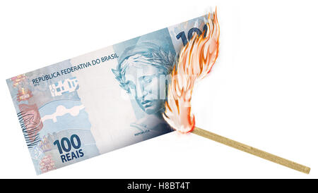 Eine Banknote wird von einer Übereinstimmung mit dem Brennen in einer großen Flamme verbrannte. Stockfoto