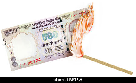 Eine Banknote wird von einer Übereinstimmung mit dem Brennen in einer großen Flamme verbrannte. Stockfoto