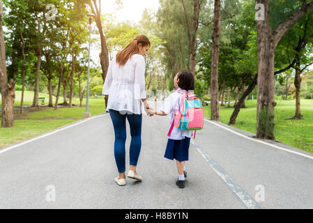 Asiatische Mutter und Tochter Schüler zu Fuß zur Schule. Schülerinnen und Schüler. Stockfoto