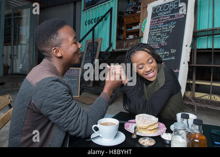 Paar Hand in Hand in einem Café in Johannesburg Stockfoto