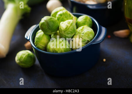 Frischer Rosenkohl in Schüssel auf einem dunklen Hintergrund Stockfoto