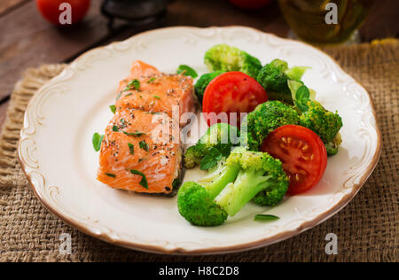 Gebackener Fisch Lachs garniert mit Brokkoli und Tomaten. Diät-Menü. Fisch-Menü. Meeresfrüchte - Lachs. Stockfoto