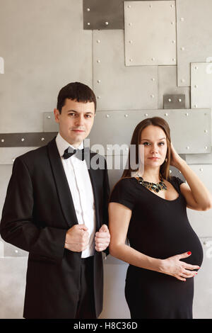 Schwanger Liebespaar zusammen Blick in die Kamera. Elegante schwangere Frau. Stockfoto
