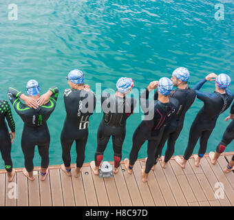 Triathlon-Schwimmstart. Triathleten in Wetsuits zu Beginn des Rennens Stockfoto