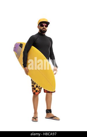 In voller Länge Portrait von ein Surfer in einen Neoprenanzug hält ein Surfbrett isoliert auf weißem Hintergrund Stockfoto