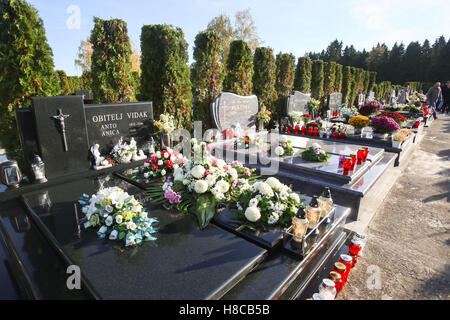 Gräber geschmückt mit Blumenarrangements und Lampions am Friedhof an Allerheiligen in Velika Gorica, Kroatien. Stockfoto