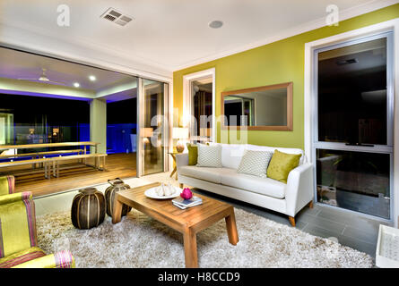 In einem modernen Haus Wohnbereich mit Kissen auf den weißen Sofas und einem kleinen Holztisch auf einem bunten Teppich Fell. Stockfoto