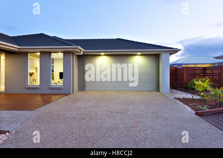 Bestandteil dieses Luxus-Haus gehört eine Garage mit eine weiße Tür und durch zwei kleine Lampen unter der Decke beleuchtet. Stockfoto