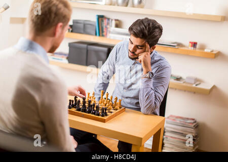 Zwei junge Männer spielen Schach im Zimmer Stockfoto