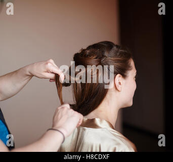 Friseur macht die Braut Frisur in Hochzeitsmorgen Stockfoto