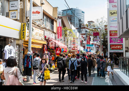 Japan, Tokio, Harajuku, Takeshita-dori. Blick entlang der Straße mit ACDC Rag und anderen Stores, besetzt mit Leuten, Touristen und Käufer. Tagsüber. Stockfoto