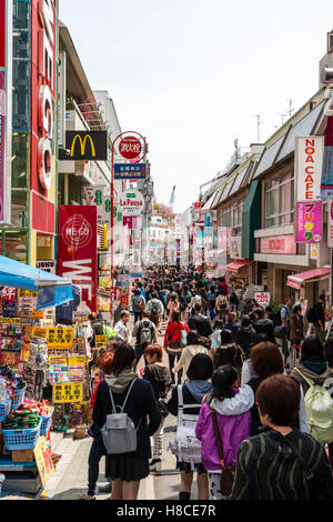 Japan, Tokio, Harajuku. Blick entlang der Fußgängerzone Takeshita Straße mit Menschen am Mittag, von McDonalds und kleine Boutiquen und Geschäften voll. Stockfoto