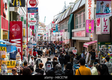 Japan, Tokio, Harajuku. Blick entlang der Fußgängerzone Takeshita Straße mit Menschen am Mittag, von McDonalds und kleine Boutiquen und Geschäften voll. Stockfoto