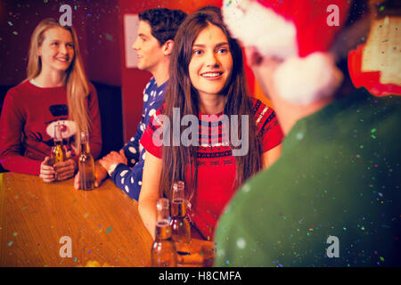 Zusammengesetztes Bild von Freunden, die Biere in der Weihnachtszeit Stockfoto