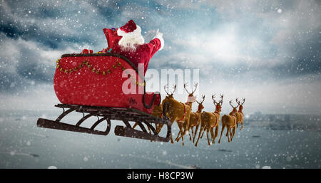 Zusammengesetztes Bild von Santa Claus in der Weihnachtszeit auf Schlitten fahren Stockfoto