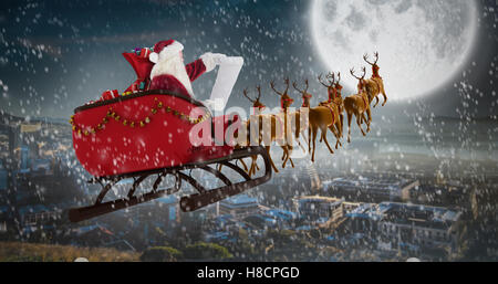 Zusammengesetztes Bild des Weihnachtsmannes Reiten auf Schlitten in der Weihnachtszeit Stockfoto