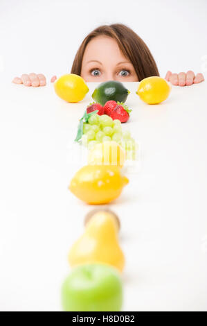 Frau hinter einer Reihe von Früchten Stockfoto
