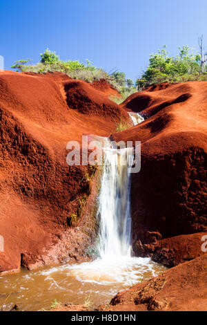 Ein kleiner Wasserfall Graben durch rote Erde in der Waimea Canyon auf Kauai, Hawaii, USA. Stockfoto