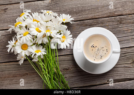 Daisy Kamille Blumen Bukett und Kaffee Tasse auf hölzernen Gartentisch. Ansicht von oben Stockfoto