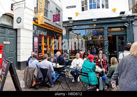 Die Menschen trinken und essen außerhalb marwood Coffee Shop und Cafe coho in den Gassen von Brighton, Großbritannien Stockfoto