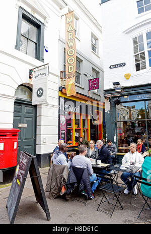Die Menschen trinken und essen außerhalb marwood Coffee Shop und Cafe coho in den Gassen von Brighton, Großbritannien Stockfoto