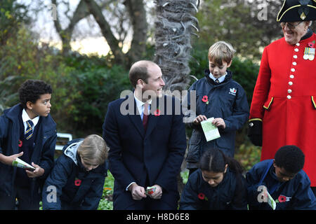 Der Duke of Cambridge hilft Kindern Pflanzensamen während eines Besuchs zu Kensington Memorial Park, London, wo er offiziell die Widmung des Parks zu Programms Centenary Felder markieren wird. Stockfoto