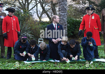 Der Duke of Cambridge hilft Kindern Pflanzensamen während eines Besuchs zu Kensington Memorial Park, London, wo er offiziell die Widmung des Parks zu Programms Centenary Felder markieren wird. Stockfoto