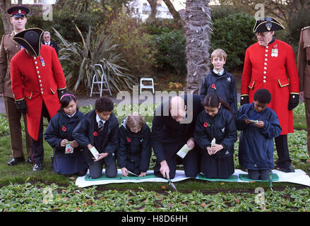 Der Duke of Cambridge hilft Kindern Pflanzensamen während eines Besuchs zu Kensington Memorial Park, London, wo er offiziell die Widmung des Parks zu Programms Centenary Felder markieren wird. Stockfoto