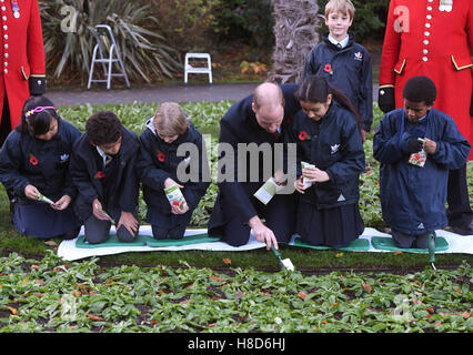 Der Duke of Cambridge hilft Kindern Pflanzensamen während eines Besuchs zu Kensington Memorial Park, London, wo er offiziell die Widmung des Parks zu Programms Centenary Felder markieren wird. Stockfoto