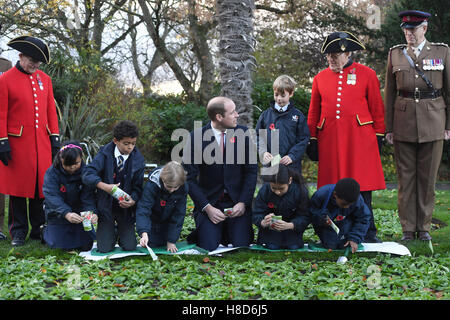 Der Duke of Cambridge hilft Kindern Pflanzensamen während eines Besuchs zu Kensington Memorial Park, London, wo er offiziell die Widmung des Parks zu Programms Centenary Felder markieren wird. Stockfoto