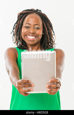 Eine schwarze Frau hält eine Tablette Stockfoto