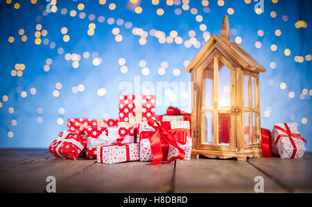 Weihnachten Hintergrund mit Haufen von Geschenken und hölzerne Laterne auf Holzbohlen gelegt Stockfoto