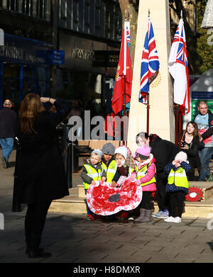 Peterborough, UK. 11. November 2016. Tag des Waffenstillstands. Kinder haben ihr Bild mit einer Mohnblume, die sie, die neben dem Kriegerdenkmal Peterborough entworfen haben genommen. Menschen, die Kennzeichnung Tag des Waffenstillstands in Peterborough, England. Eine zwei Minuten Stille ist landesweit auf der elften Stunde der elften Tag des elften Monats markiert das Ende des ersten Weltkriegs statt.  Bildnachweis: Paul Marriott/Alamy Live-Nachrichten Stockfoto