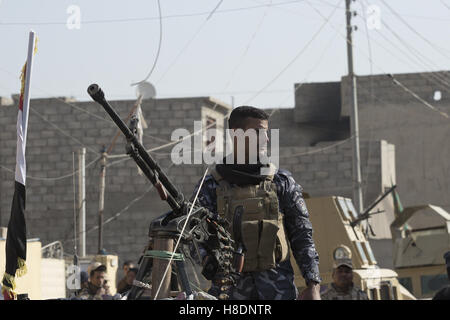 Mosul, Ninive, Irak. 11. November 2016. 11.11.2016. Mosul, Irak. Eine irakische Polizei Büro mans ein schweres Maschinengewehr auf einem Pick-up als Soldaten der 9. Panzerdivision der irakischen Armee montiert DShK Mosul Al Inisar Bezirk im Südosten der Stadt besichtigen. Stadtteil Al Intisar wurde vor vier Tagen durch irakische Sicherheit Kräfte (ISF) und, trotz seiner Nähe zu andauernden Kämpfe zwischen ISF und ISIS Militanten, viele Bewohner noch Leben in der Siedlung ohne regelmäßigen Strom und Wasser und mit schwindenden Nahrungsvorräte. Bildnachweis: ZUMA Press, Inc./Alamy Live-Nachrichten Stockfoto